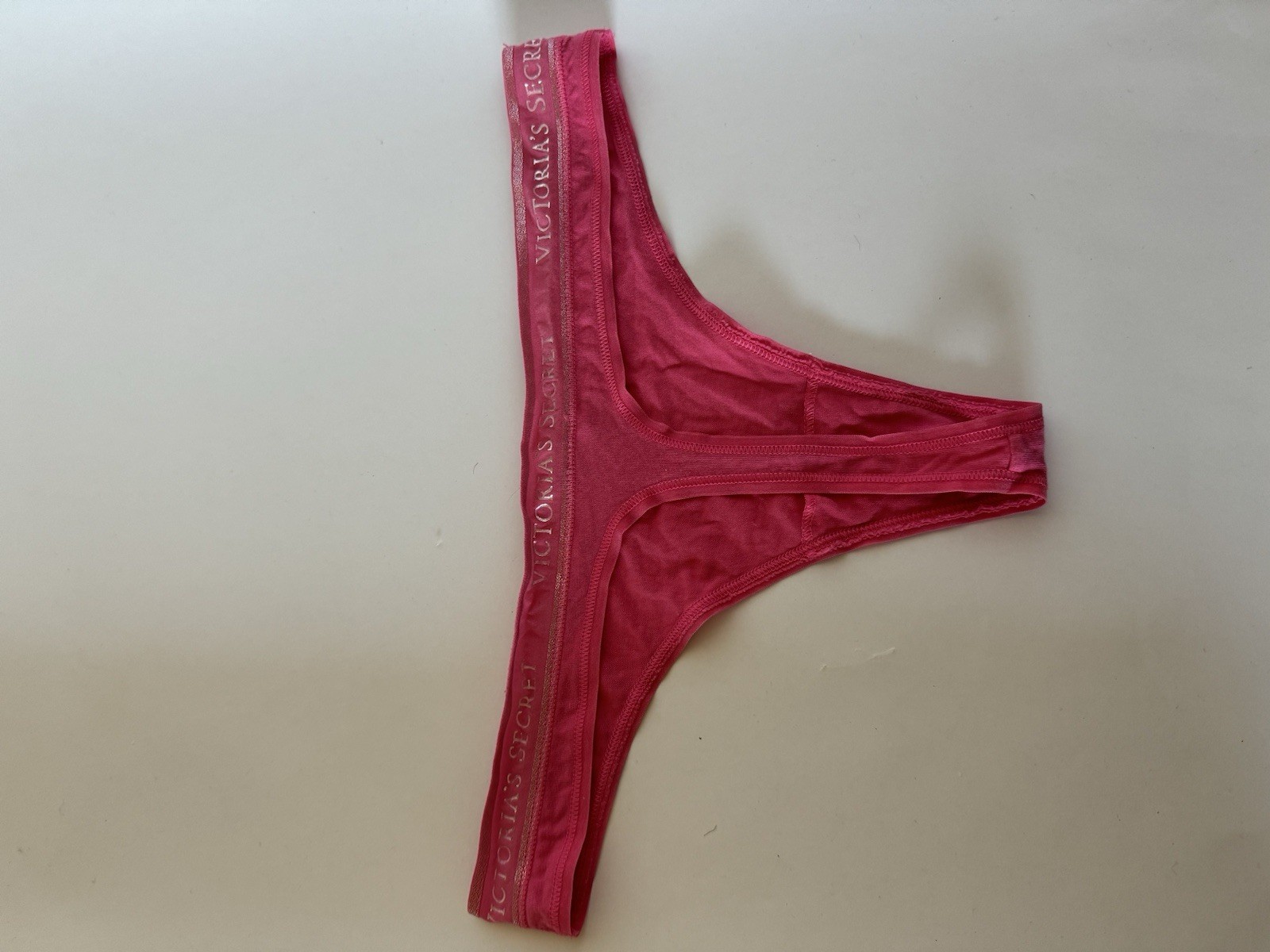 Victoria’s Secret pink thong panties with metallic logo waistband.